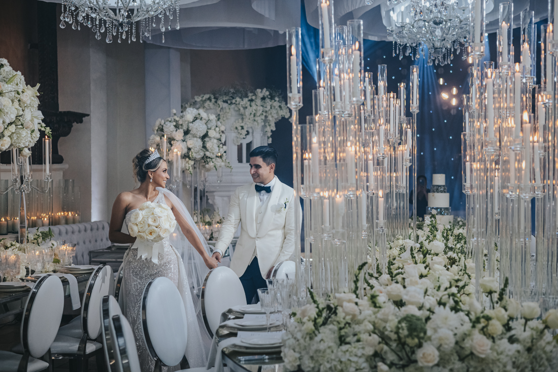 Salón de bodas con candelabros y arreglos florales blancos